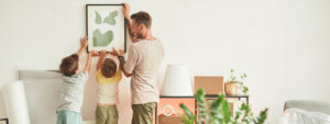 photo-of-a-father-and-children-hanging-painting